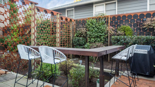 a backyard with a wooden table and chairs and a privacy fence