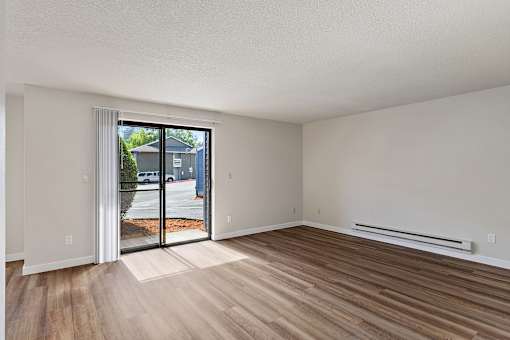 A room with a sliding glass door leading to a street.