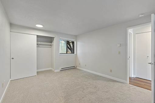 A large empty room with a window and a door.