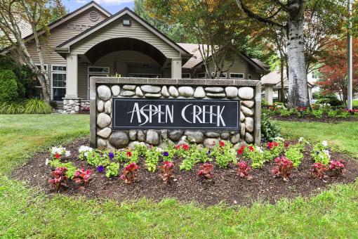 a sign in front of a house that reads aspen creek