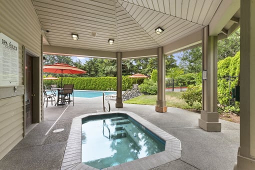 a covered patio with a jacuzzi and a pool