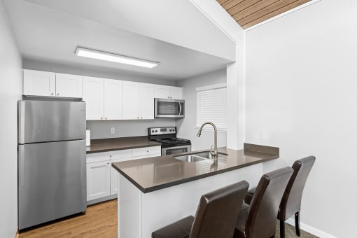 a kitchen with a island and a stainless steel refrigerator