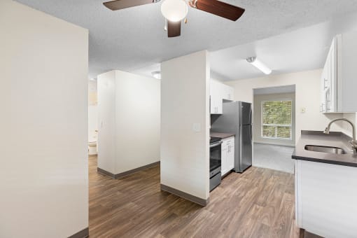 a renovated kitchen with white cabinets and a black refrigerator