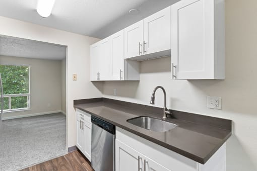 an empty kitchen with white cabinets and a sink