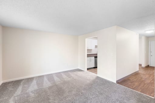 an empty living room with white walls and wood flooring