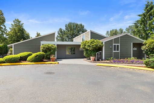 a gray house with a driveway and a parking lot
