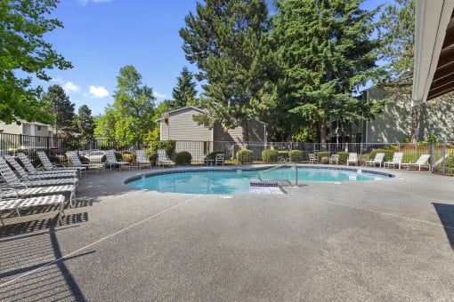 a resort style pool with chairs around it and trees