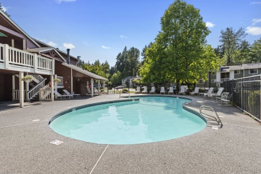 the resort style pool is surrounded by buildings and trees