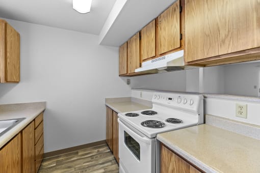 a kitchen with white appliances and wood cabinets