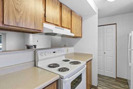 a kitchen with white appliances and wooden cabinets and a white refrigerator