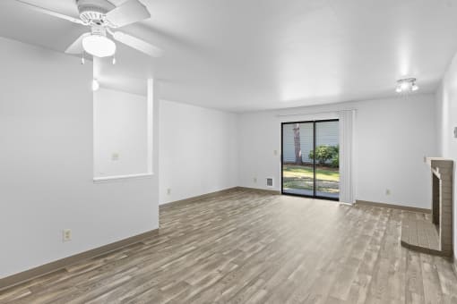 the living room and dining room of a new home with white walls and wood floors