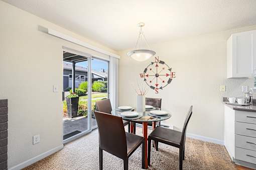 A dining room with a table set for two and a compass rose on the wall.