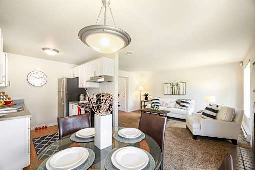 A modern dining room with a glass table and chairs.
