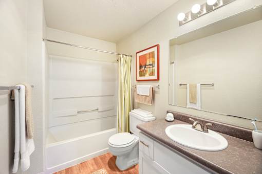 A white toilet sits in a bathroom next to a sink.