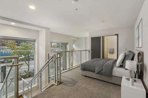 a bedroom with a bed and a staircase in front of it