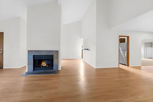 A modern living room with a fireplace and hardwood floors.