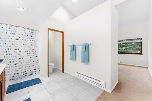 A bathroom with a blue and white shower curtain.