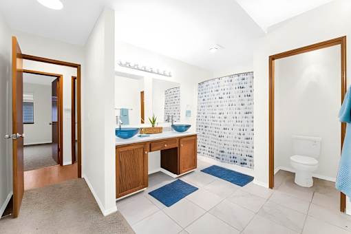 A bathroom with a toilet, sink, and mirror.