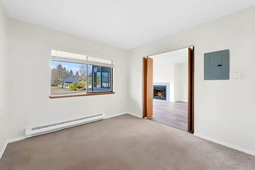 A room with a window, a door, and a wall socket.