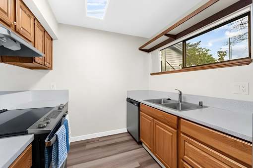 A kitchen with wooden cabinets and a skylight.