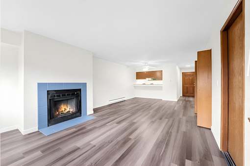 A room with a fireplace and wood flooring.