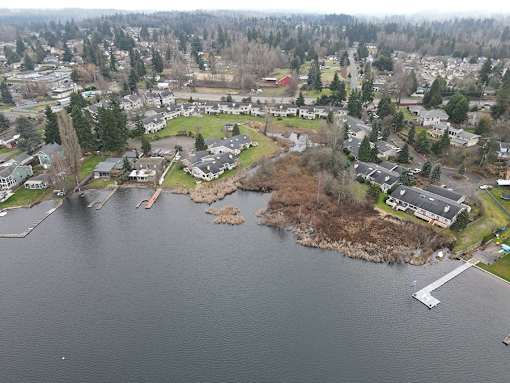 A small island in the middle of a lake surrounded by houses.
