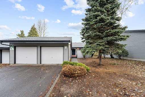 A house with a grey roof and a white garage door.