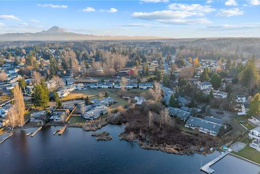 A small town with a lake and a mountain in the background.