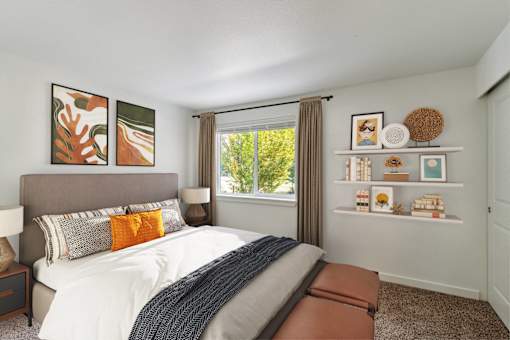 A bedroom with a large bed and a window with a view of trees.