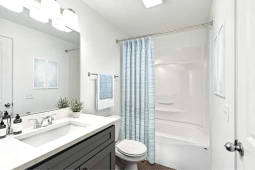 A bathroom with a white sink, toilet, and bathtub.