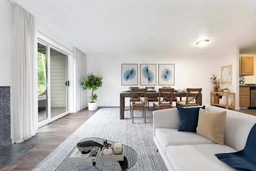 A modern living room with a white couch and a dining table.