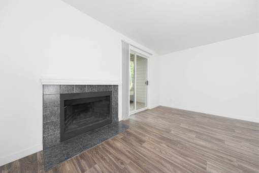 A room with a fireplace and wooden flooring.