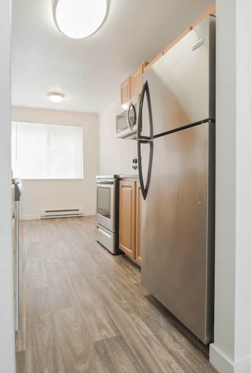 A modern kitchen with a refrigerator, oven, and microwave.