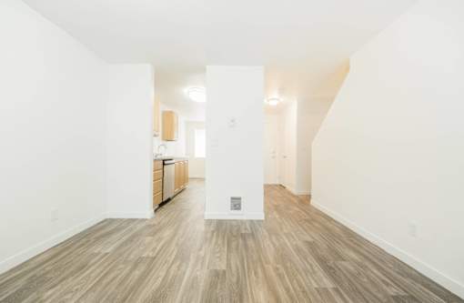 A room with wooden flooring and white walls.