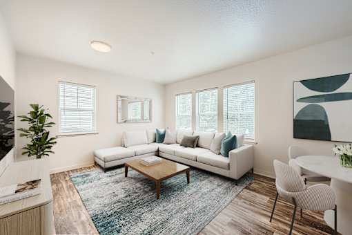 A living room with a white couch, a coffee table, and a rug.