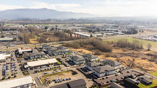A large building complex with a parking lot in front of it.
