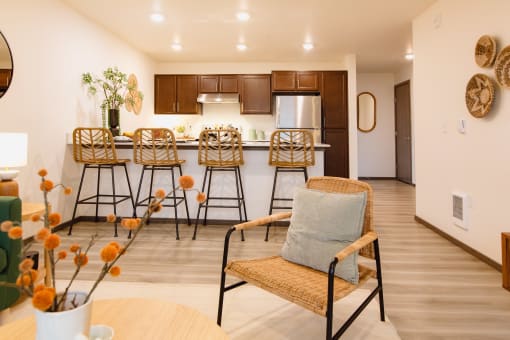 a living room with a bar and a kitchen with stools