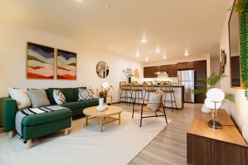 a living room with a couch and a table in front of a kitchen