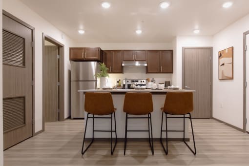 a kitchen with a island with three stools in front of it