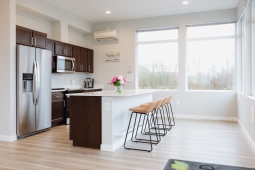 a kitchen with stainless steel appliances and a counter with stools