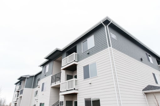 a white and gray apartment building with balconies