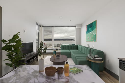 a living room with a green couch and a large window