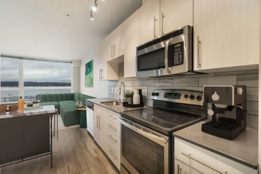 a kitchen with white cabinets and stainless steel appliances