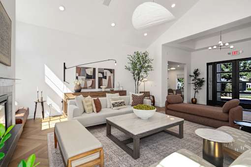 A living room with a white couch, a coffee table, and a fireplace.