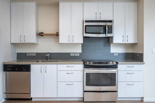 a kitchen with white cabinets and stainless steel appliances