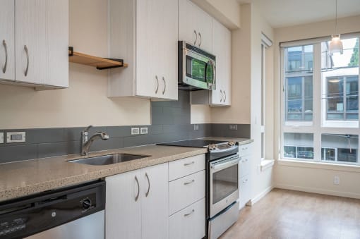 a kitchen with white cabinets and a sink and a microwave