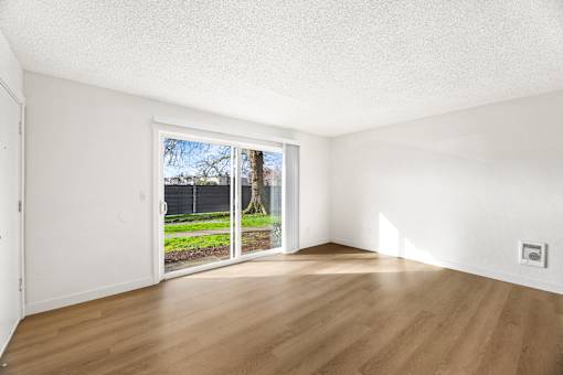 A room with a sliding door leading to a backyard.
