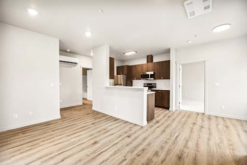 A kitchen with white cabinets and a wooden floor.