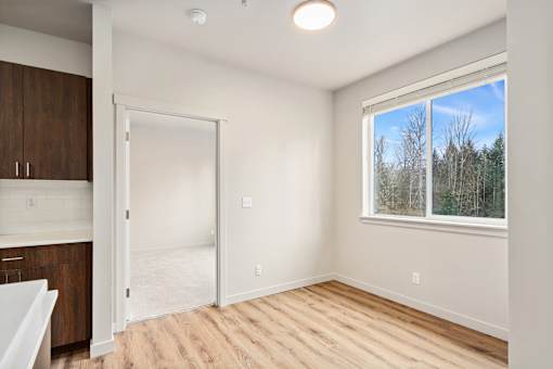A room with a window and a door leading to another room.