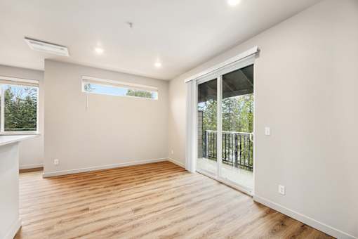 A room with a sliding glass door leading to a balcony.